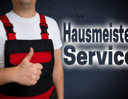 Schriftzug Hausmeister Service mit davorstehendem Handwerker