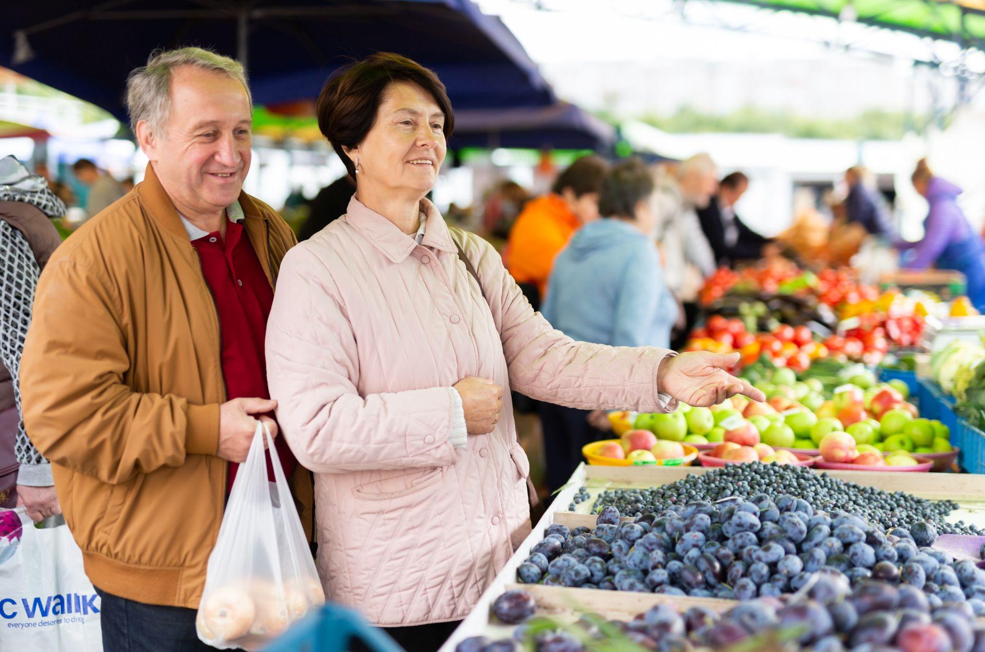Senioren kaufen frisches Obst und Gemüse am Markt